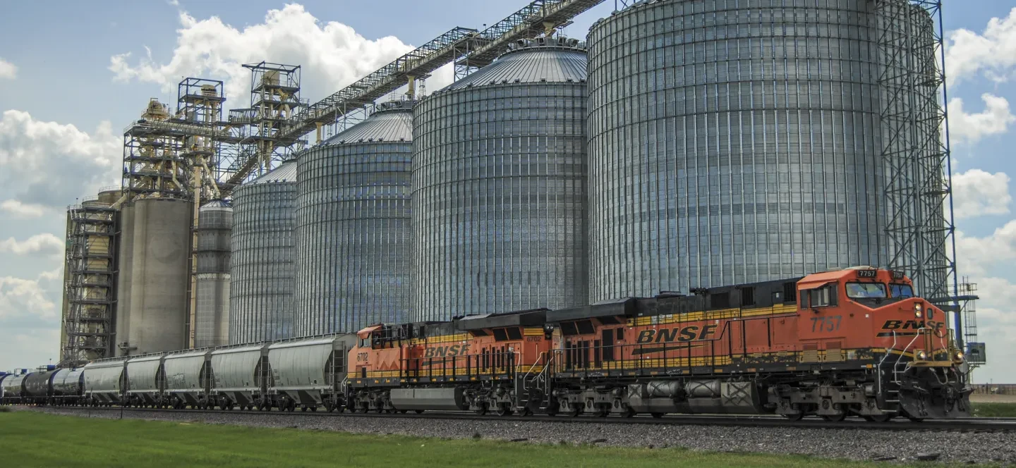 BNSF locomotive in front of grain silos